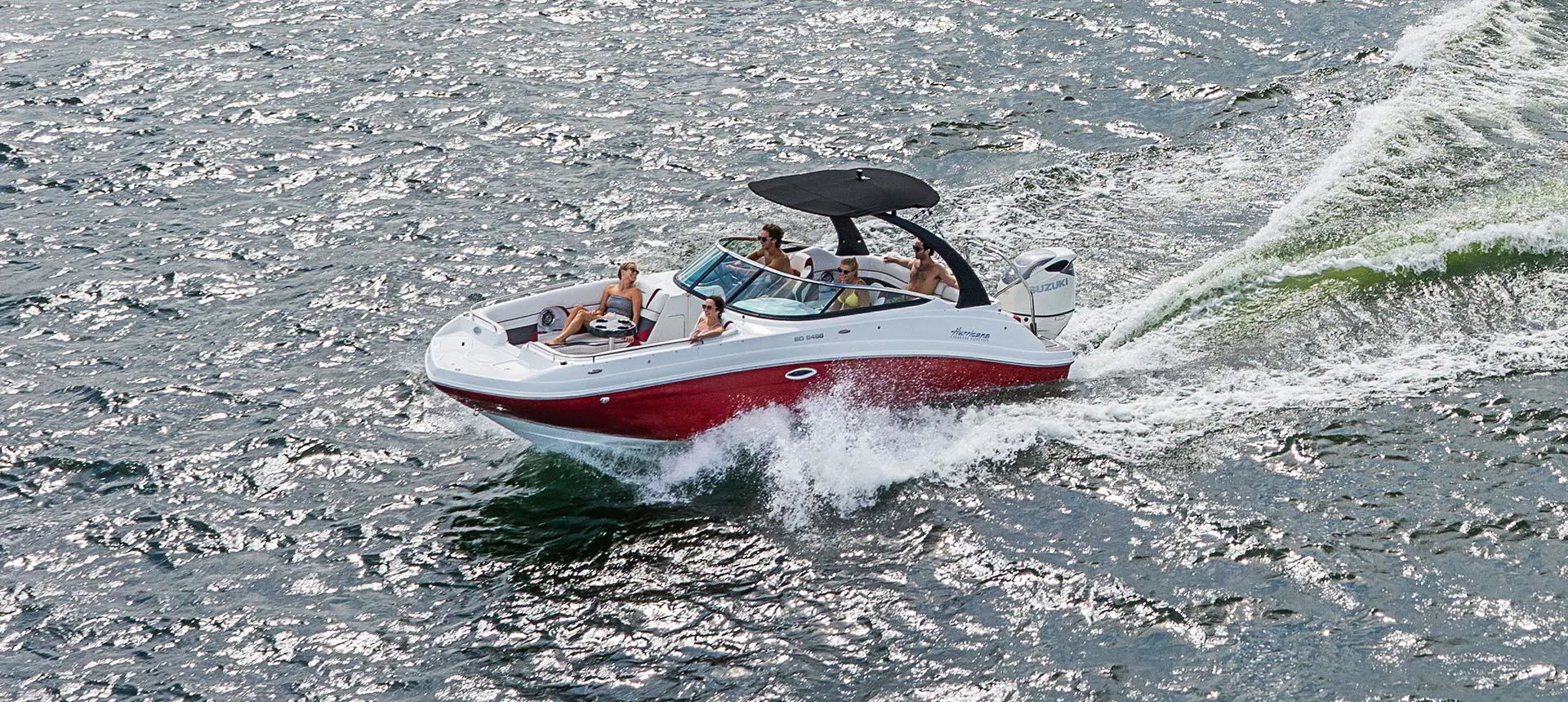 Front view of a Hurricane SunDeck 2486 OB cruising on lake.