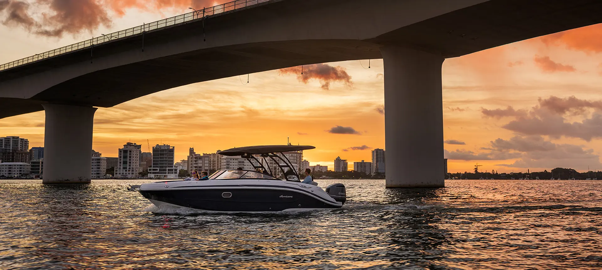 Hurricane Sundeck 2600 OB deck boat parked on the ocean at sunset.