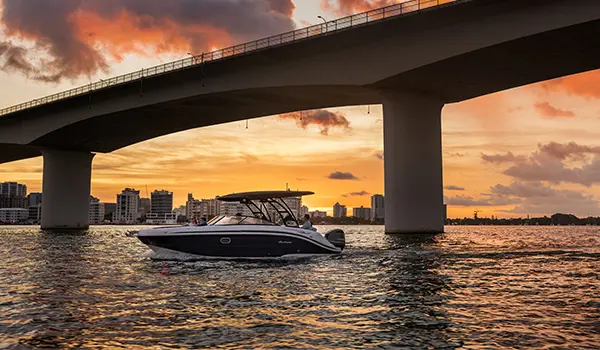 Hurricane Sundeck 2600 OB deck boat parked on the ocean at sunset.