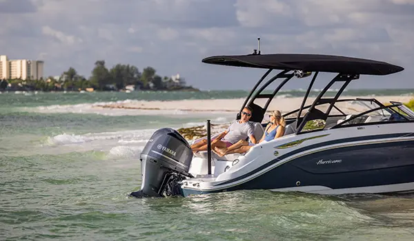 2 people relaxing on the stern seats on a Hurricane Sundeck 2600 OB deck boat.