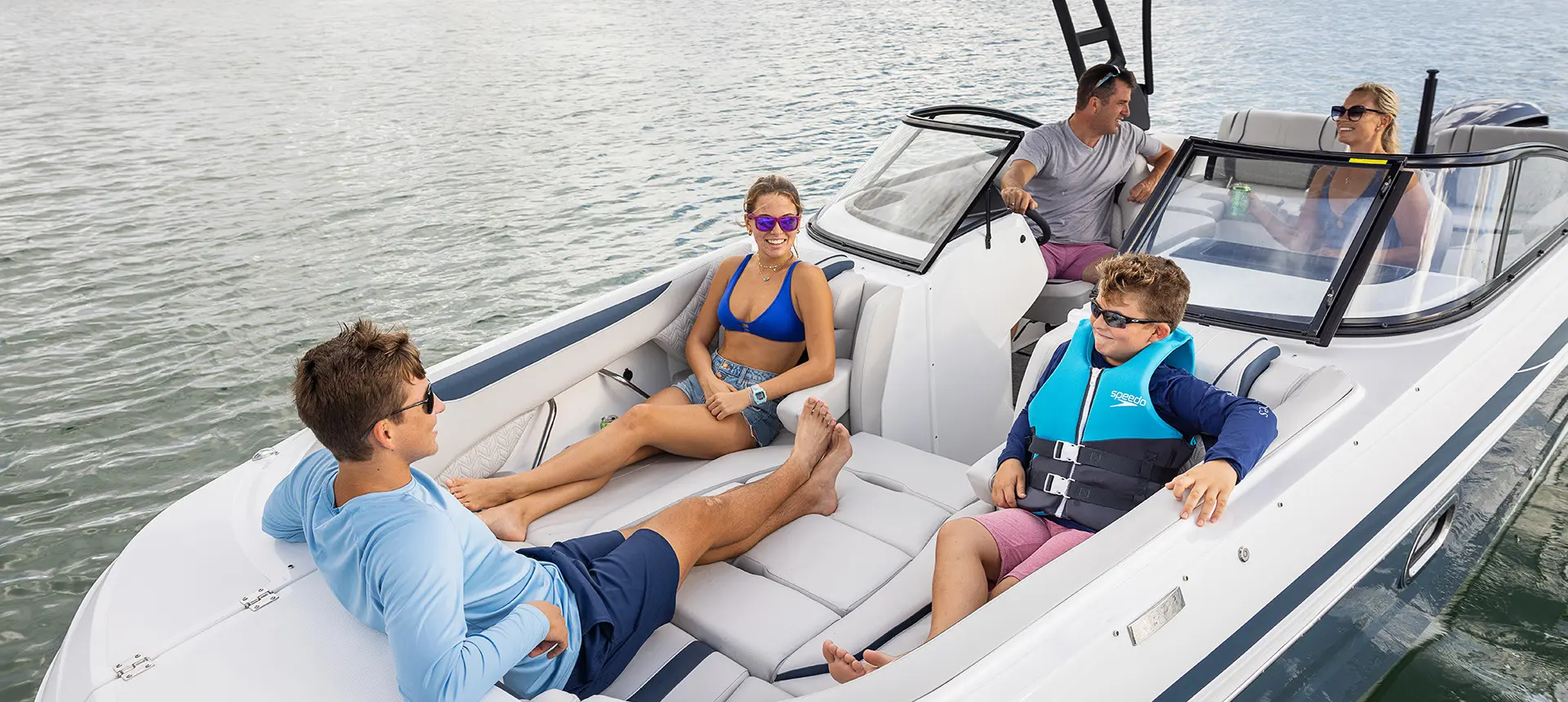 Family relaxing on the bow seats on a Hurricane Sundeck 2600 OB deck boat.