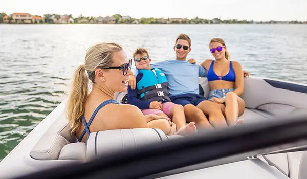 Mom smiles next to family on a Hurricane Sundeck 2600 OB deck boat.