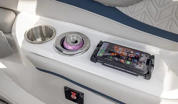 Integrated cup holders and wireless charging pad on the helm of a Hurricane Sundeck 2600 OB Deck Boat.