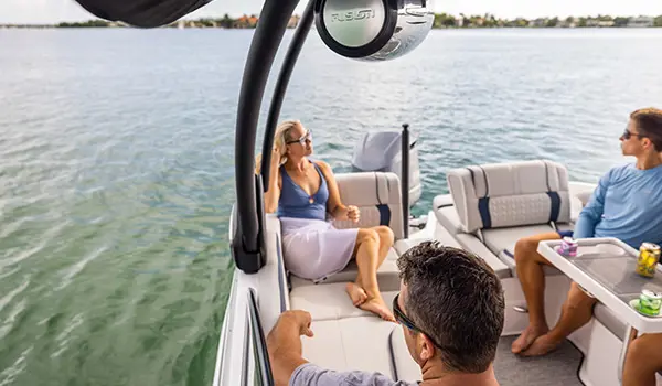 man at the helm and woman sitting in the background comfortably on a hurricane sundeck 2600 ob deck boat