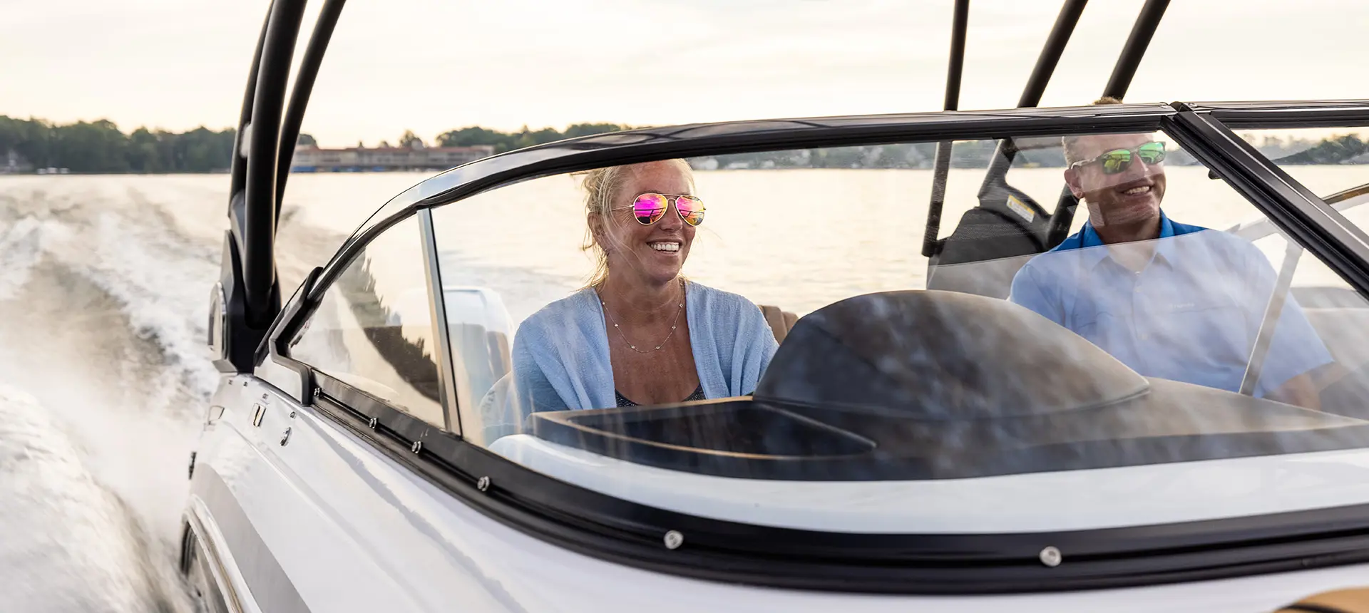 woman smiling at the helm of a hurricane sundeck 2600 ob deck boat