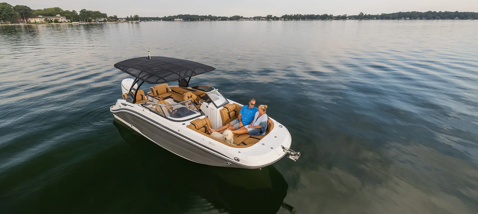 aerial view of a couple relaxing on the bow with their dog on a hurricane sundeck 2600 ob deck boat