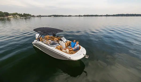 aerial view of a couple relaxing on the bow with their dog on a hurricane sundeck 2600 ob deck boat