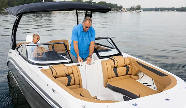 man closing the walk through windshield gate on a hurricane sundeck 2600 ob deck boat