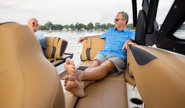 man relaxing on the stern swingback seat on a hurricane sundeck 2600 ob deck boat