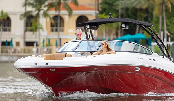 woman relaxing on the bow seating while the man at the helm smiles at her on a hurricane sundeck 2690 ob deck boat
