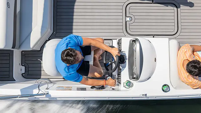 aerial view of a man at the helm of a hurricane sundeck sport i/o boat