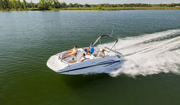 Hurricane SunDeck Sport 188 IO deck boat speeding across a lake.