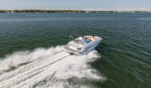 Stern focused view of a Hurricane SunDeck Sport 188 IO deck boat cruising on a lake.