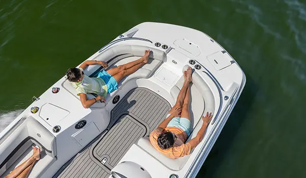 2 boys lounging on the bow seats on a Hurricane SunDeck Sport 188 IO deck boat.