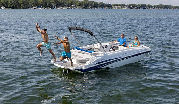 Kids jumping into the lake off the stern of a Hurricane SunDeck Sport 188 IO deck boat.