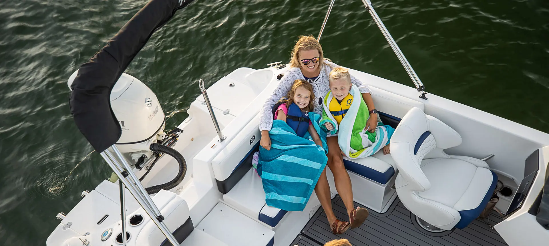 overhead view of a mother and kids smiling on the stern couch on a hurricane sundeck sport ob boat