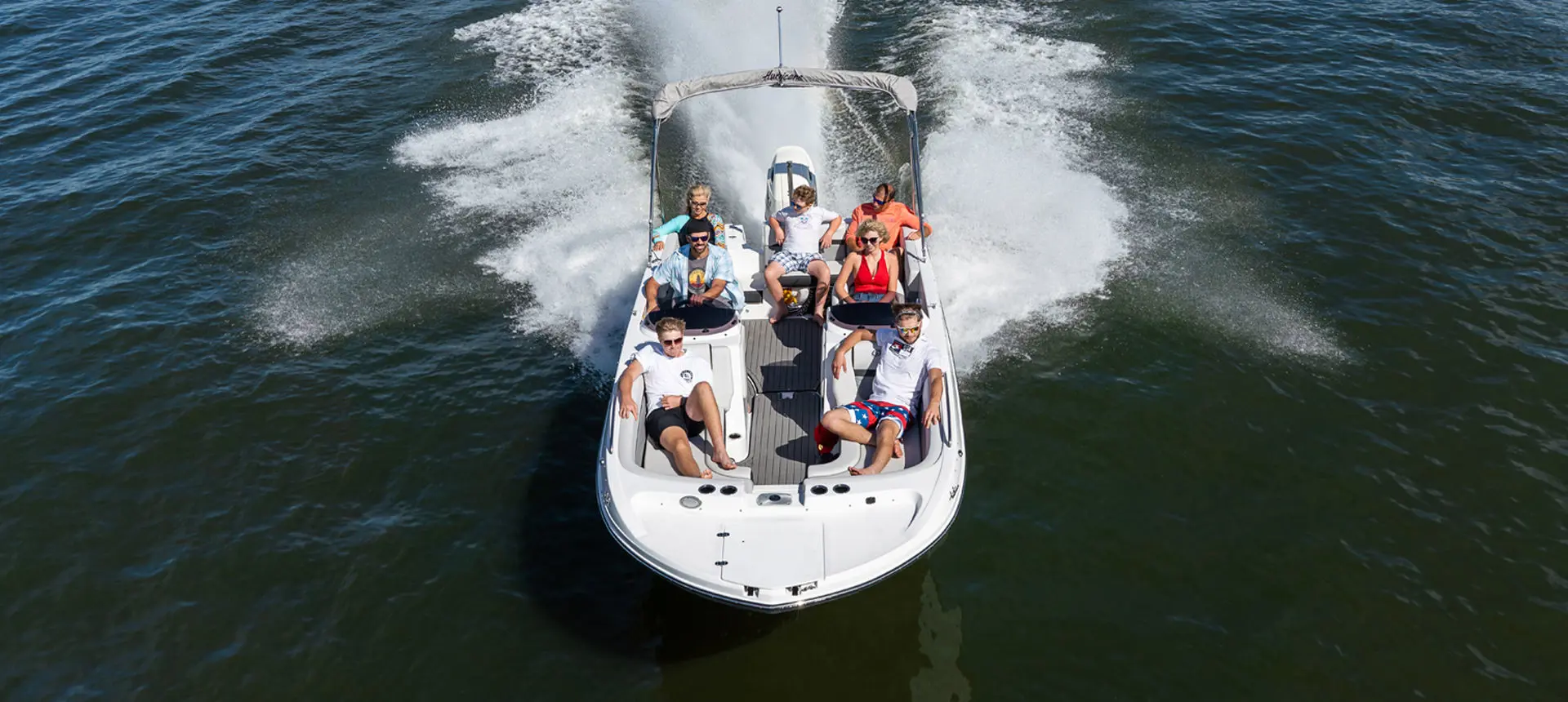fully loaded hurricane sundeck sport ob boat driving on a lake