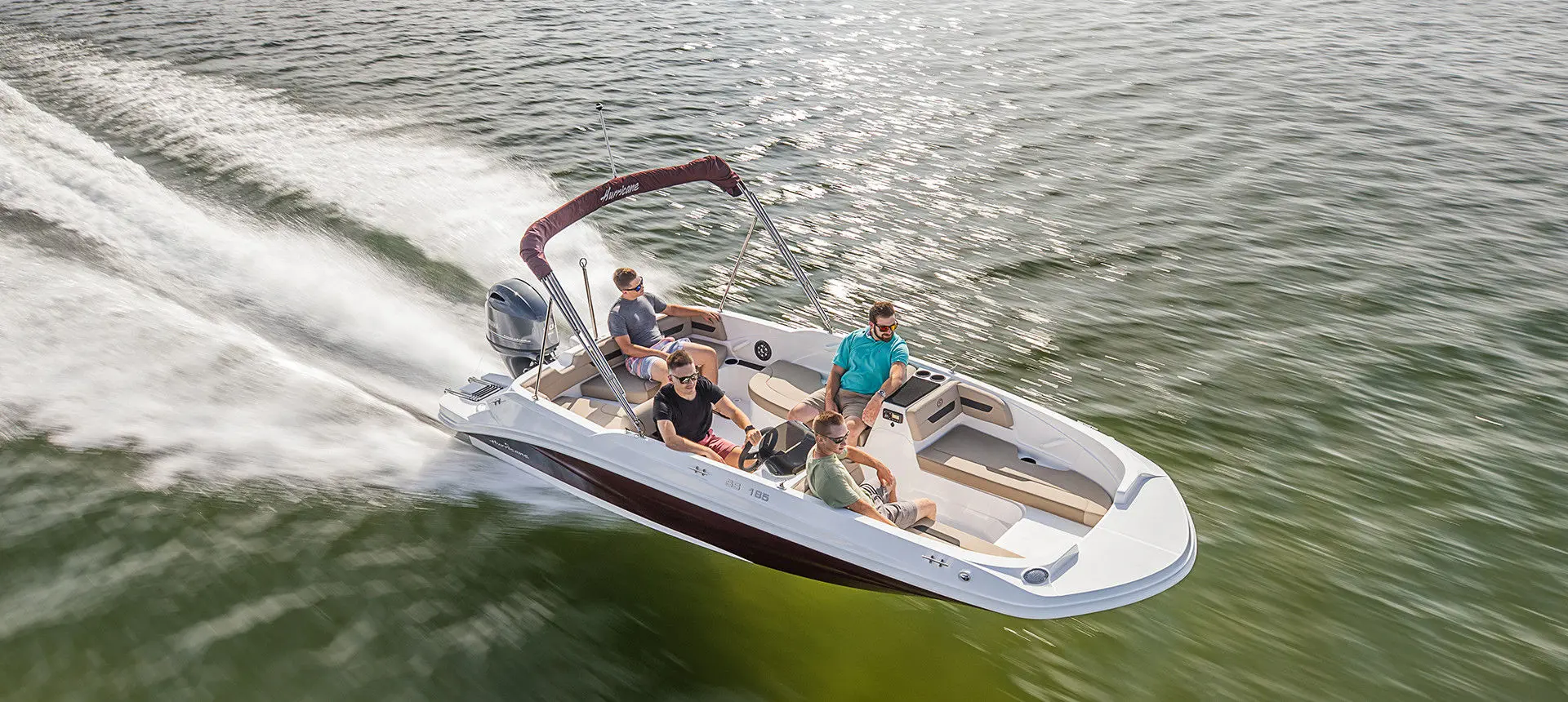 aerial view of 4 men cruising the lake on a hurricane sundeck sport ob ss 185 boat