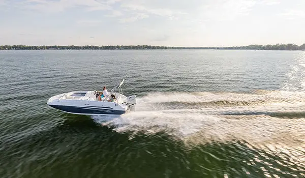 Hurricane SunDeck Sport 188 OB deck boat cruising on a lake.