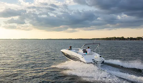 Stern focused view of a Hurricane SunDeck Sport 188 OB deck boat on a lake.