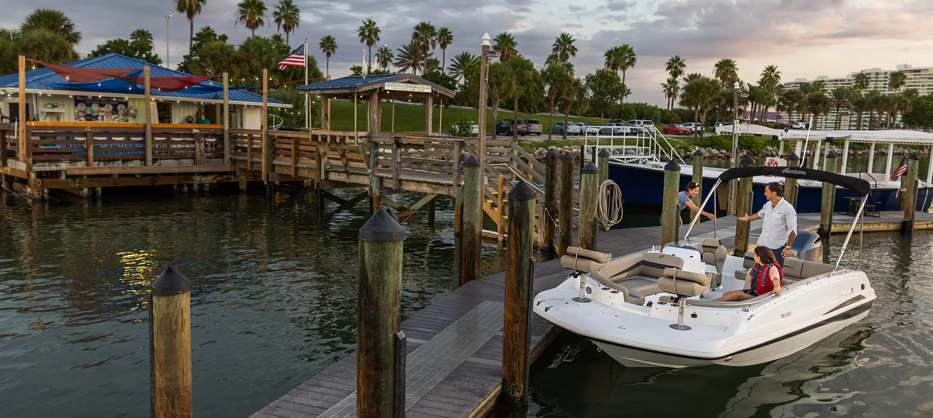 family boarding a hurricane sport 201 ob deck boat at the dock