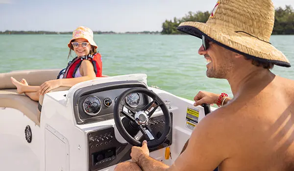 man at the helm smiling at his daughter on a hurricane sport 201 ob deck boat