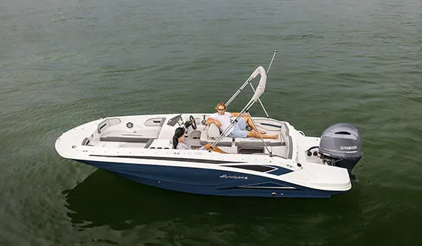 Aerial view of a couple lounging on the stern seats of a Hurricane SunDeck Sport 205 OB deck boat.