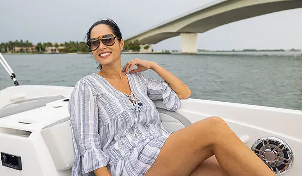 Woman relaxing on the stern lounge seating on a Hurricane SunDeck Sport 205 OB deck boat.