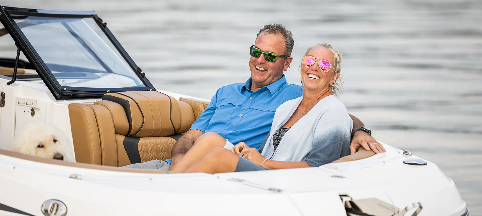 couple smiling on the bow seats on a hurricane entertainment boat