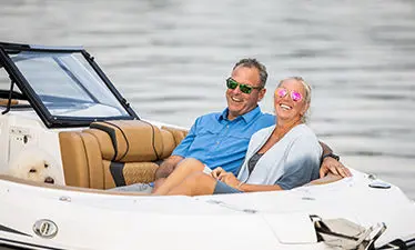 couple smiling on the bow seats on a hurricane entertainment boat