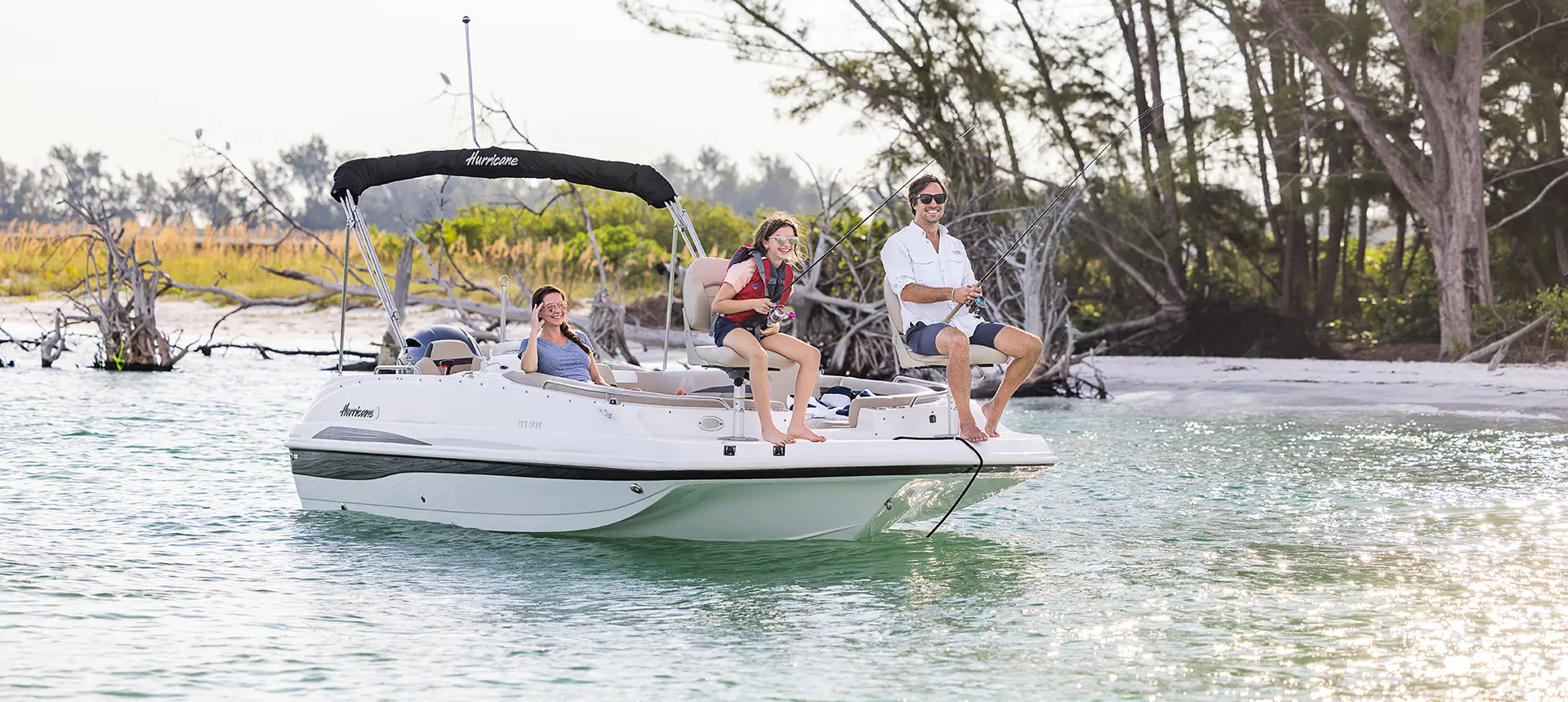 father and child fishing off the bow of a hurricane deck boat while mom watches
