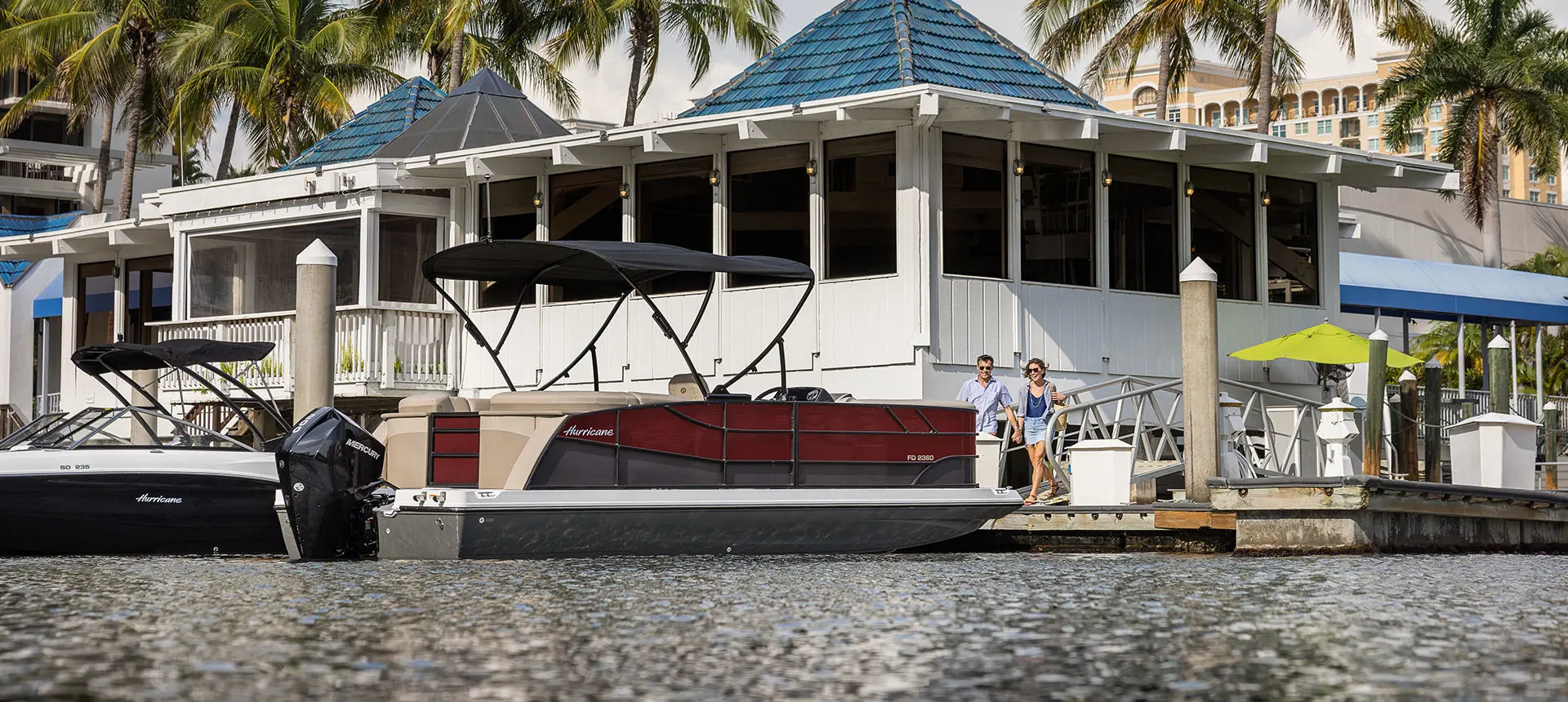 couple walking towards a docked hurricane fundeck boat