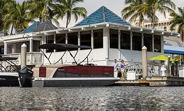 couple walking towards a docked hurricane fundeck boat