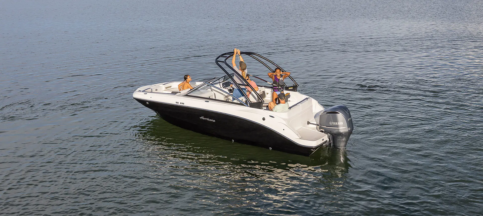 person hooking a rope to the ski tow pylon on a hurricane sport boat