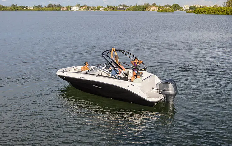person hooking a rope to the ski tow pylon on a hurricane sport boat
