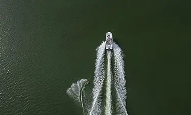 a hurricane sport boat pulling a wake boarder
