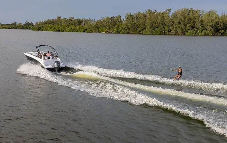 girl wake boarding behind a hurricane sport boat