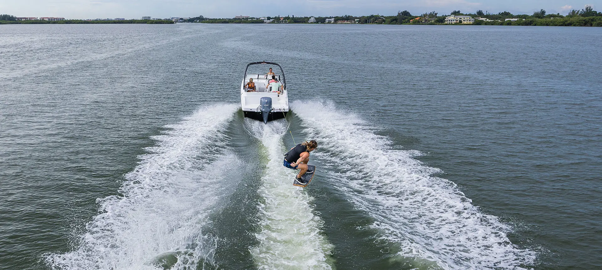 wake boarder jumping waves behind a hurricane sport boat