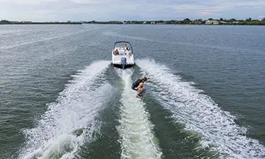wake boarder jumping waves behind a hurricane sport boat