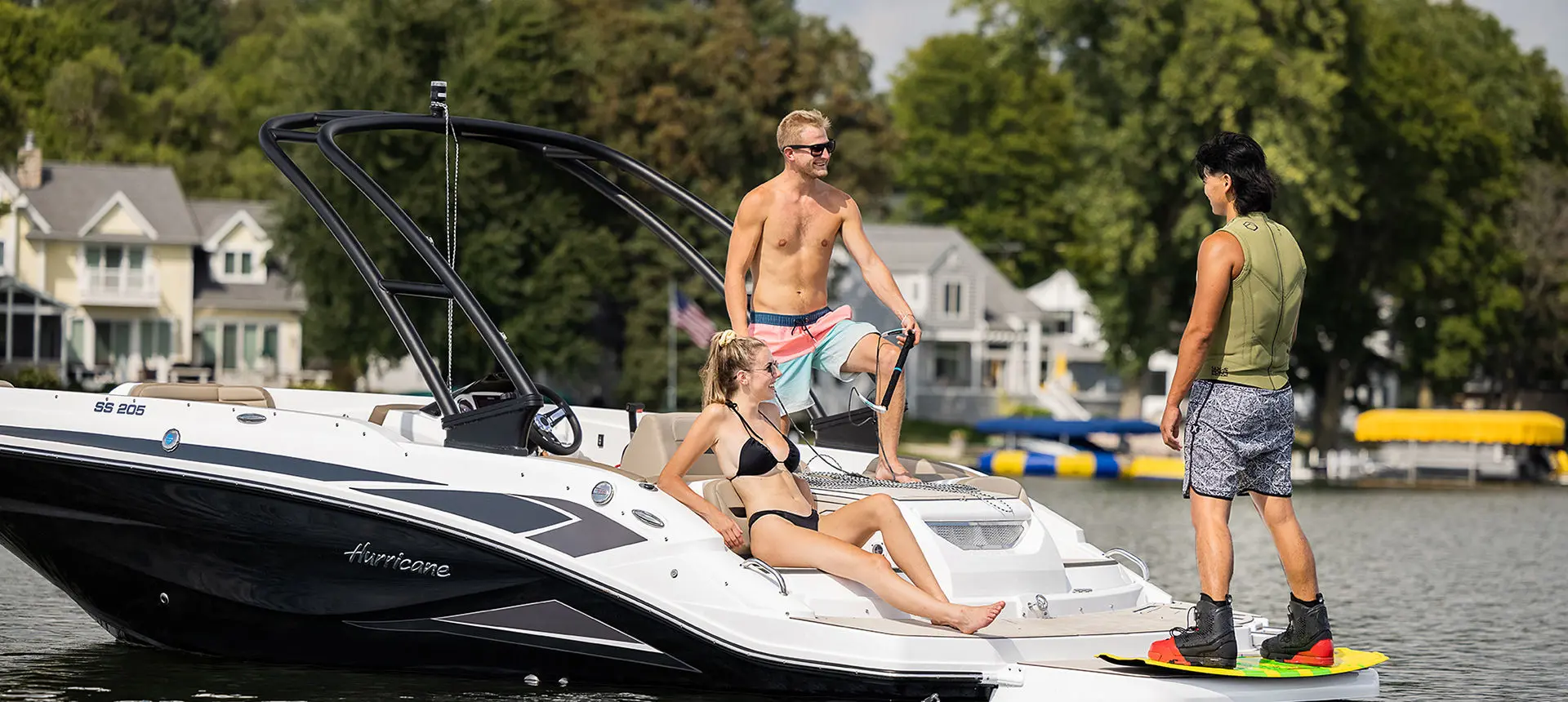 people talking to a wake boarder on the stern of a hurricane sport boat