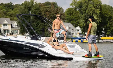 people talking to a wake boarder on the stern of a hurricane sport boat