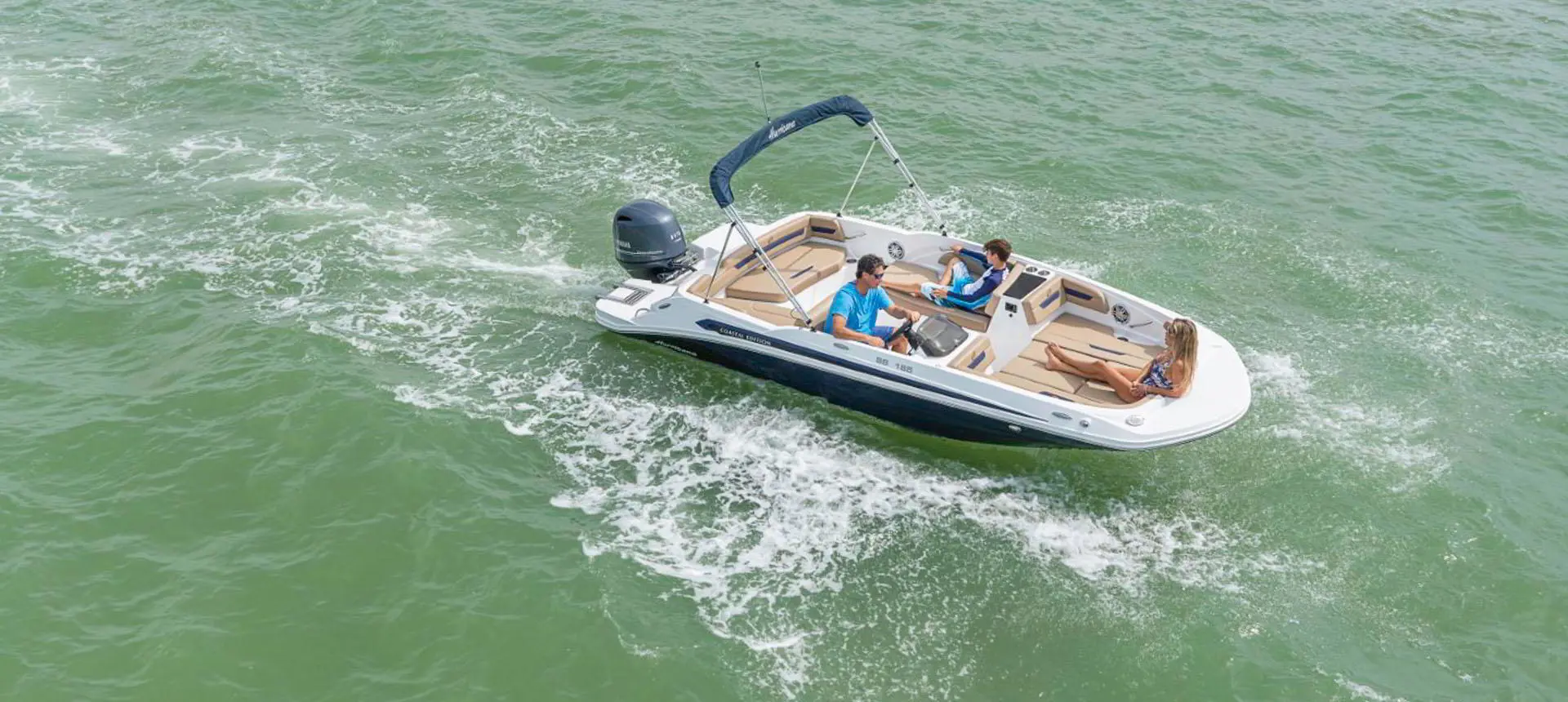 3 people enjoying the lake on a Hurricane SunDeck Sport 185 OB deck boat.