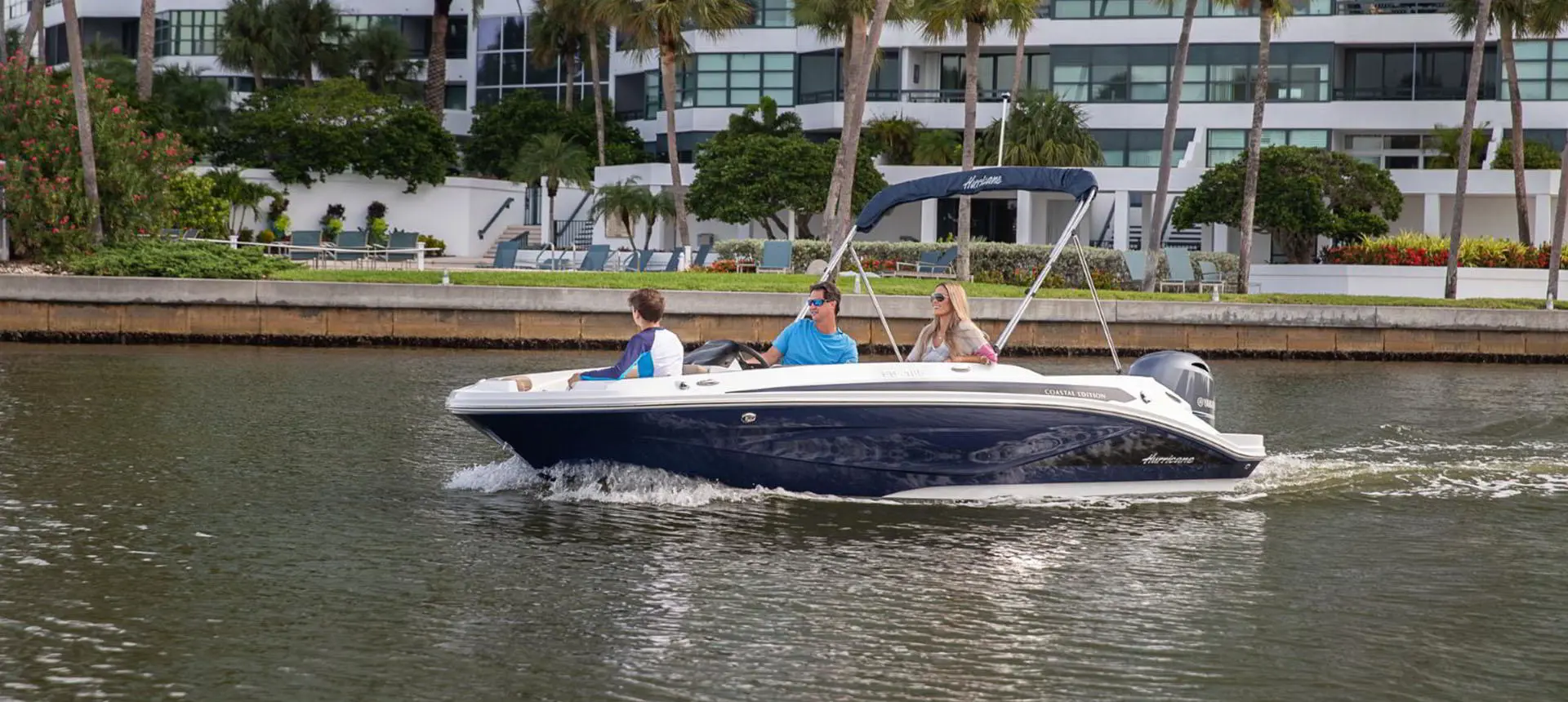 3 people heading out onto the lake on their Hurricane SunDeck Sport 185 OB deck boat.