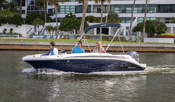 3 people heading out onto the lake on their Hurricane SunDeck Sport 185 OB deck boat.