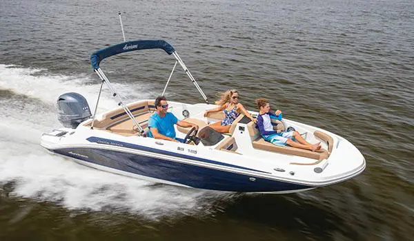 Hurricane SunDeck Sport 185 OB deck boat cruising across a lake.