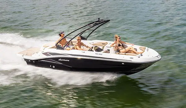 3 people cruising a lake on a Hurricane SunDeck Sport 205 IO deck boat.