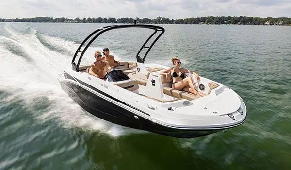 Bow focused view of 3 people cruising the lake on a Hurricane SunDeck Sport 205 IO deck boat.