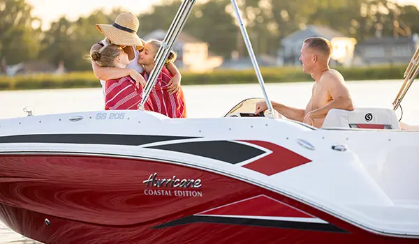 A mom wrapping her two daughters in a towel on a Hurricane SunDeck Sport 205 OB deck boat.