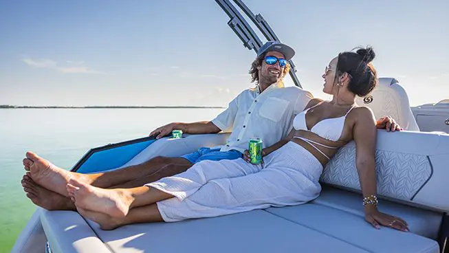couple relaxing on the swingback seat on the stern of a hurricane fundeck boat
