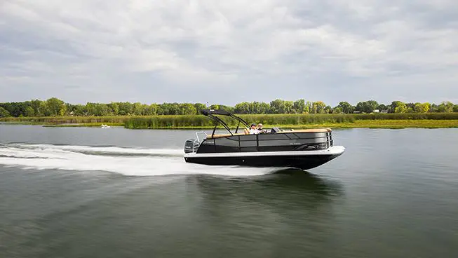 side profile of a hurricane fundeck boat cruising on a lake